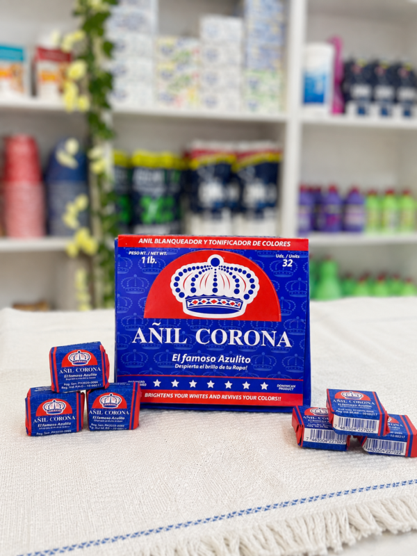 Caja de Añil Corona, el famoso jabón azulito, junto a cubitos individuales sobre un mantel blanco, en exhibición de tienda